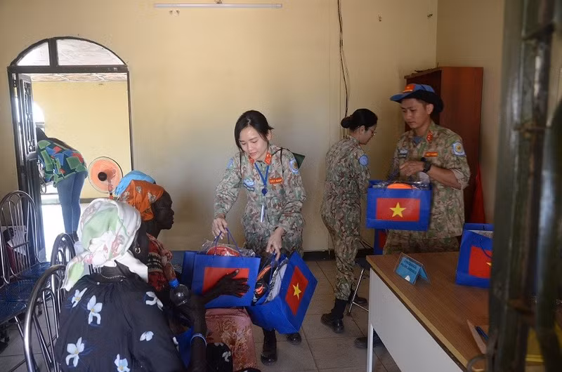 Des médecines et infirmières de la rotation 5 de l’hôpital de campagne de niveau 2 du Vietnam offrent des cadeaux aux femmes lors du voyage bénévole. Photo : baoquocte.vn