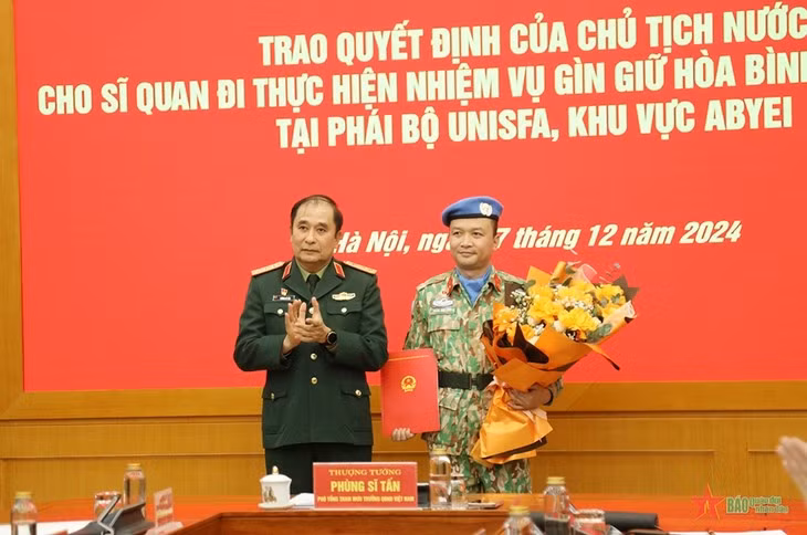 Le général de corps d’armée Phung Si Tân (à gauche) remet la décision d'affectation au lieutenant-colonel Hoàng Dinh Công. Photo : qdnd.vn