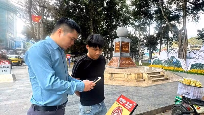 Un touriste s'enregistre au kilomètre 0, ville de Hà Giang. Photo : NDEL.