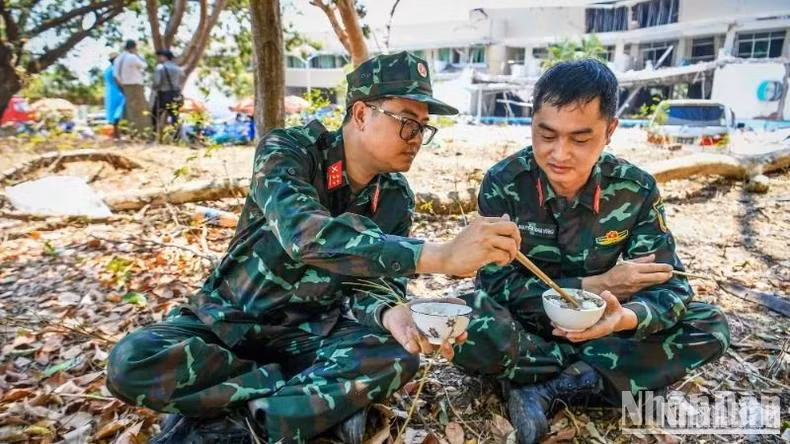 Deux sauveteurs de l'Armée populaire du Vietnam prennent le déjeuner afin de se préparer pour le quart de l'après-midi. Photo : Thanh Dat/NDEL. Deux sauveteurs de l'Armée populaire du Vietnam prennent le déjeuner afin de se préparer pour le quart de l'après-midi. Photo : Thanh Dat/NDEL.