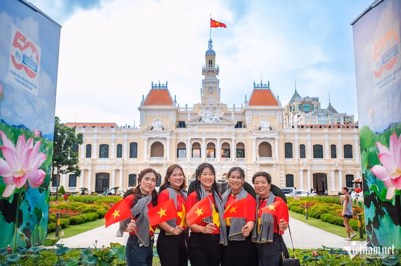 Un groupe d’employés d’une entreprise prend des photos dans des lieux emblématiques liés à la célébration du 30 avril. Ils avouent n’avoir jamais éprouvé un amour aussi intense pour leur pays ni une fierté aussi grande. Photo : Vietnamnet.
