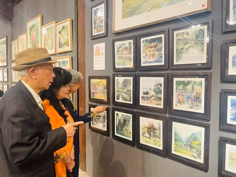 Le public est impressionné par la série de peintures représentant des sites emblématiques du Vietnam, réalisées à l'aquarelle et à l'encre par l’artiste Minh Dàm, l’un des artistes de renommée internationale et cofondateur de l’Association des Aquarellistes de Pologne. Photo: NDEL. Le public est impressionné par la série de peintures représentant des sites emblématiques du Vietnam, réalisées à l'aquarelle et à l'encre par l’artiste Minh Dàm, l’un des artistes de renommée internationale et cofondateur de l’Association des Aquarellistes de Pologne. Photo: NDEL.