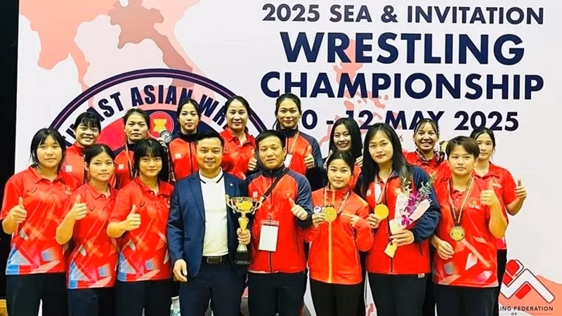 Les membres de l’équipe nationale de lutte du Vietnam posent avec la coupe du vainqueur par équipes. Photo : NDEL.