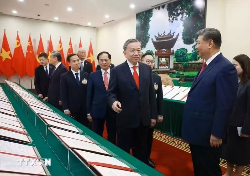 Le secrétaire général du Parti du Parti communiste du Vietnam, To Lam, et le secrétaire général du Parti et président chinois Jinping assistent à la présentation des documents de coopération entre les deux pays. Photo : VNA.