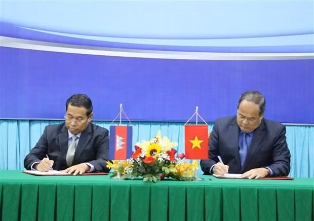 Le président du Comité populaire d'An Giang, Nguyen Thanh Binh (droite) et le gouverneur de Takeo, Ouch Phea ont signé un accord de coopération entre An Giang et Takeo pour la prochaine période. Photo : VNA