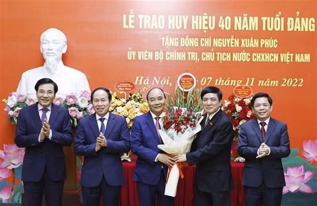 Des dirigeants félicitent le Président Nguyên Xuân Phuc (au milieu). Photo : VNA.