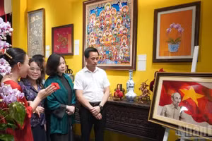 Lors de la cérémonie de lancement, les délégués admirent le portrait brodé du président Hô Chi Minh. Photo: NDEL