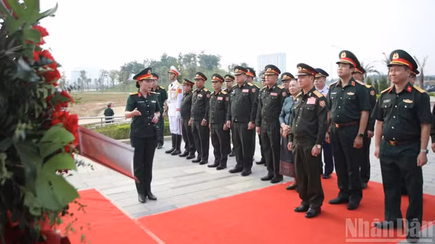 Le général Khamliang Outhakaysone et sa délégation ont déposé des fleurs et écouté une présentation sur le groupe de statues symbolisant l'unité et l'amitié Vietnam-Laos. Photo : NDEL.