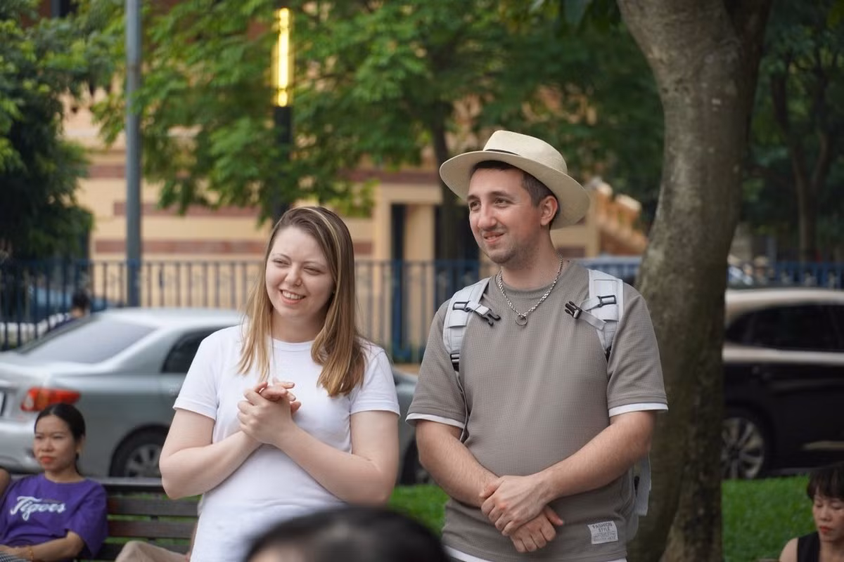 Des visiteurs étrangers écoutent attentivement les airs traditionnels qui résonnent dans le vieux quartier pendant le week-end.