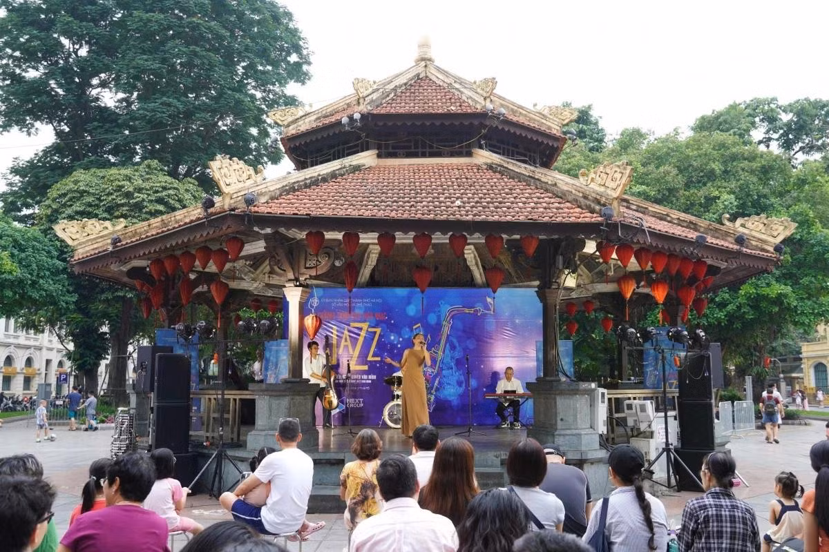 De nombreux habitants et touristes s’arrêtent pour assister au programme « Musique communautaire » organisé au Pavillon octogonal, au bord du lac Hoan Kiem.