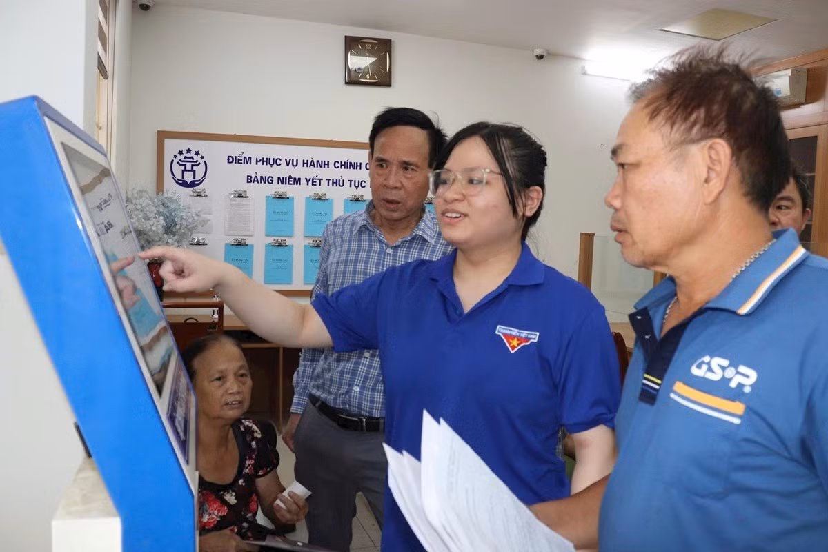 Les membres de l'Union des jeunes de la commune de Bat Trang aident les habitants au guichet de services administratifs publics de la commune. Photo : Phuong Loc. 