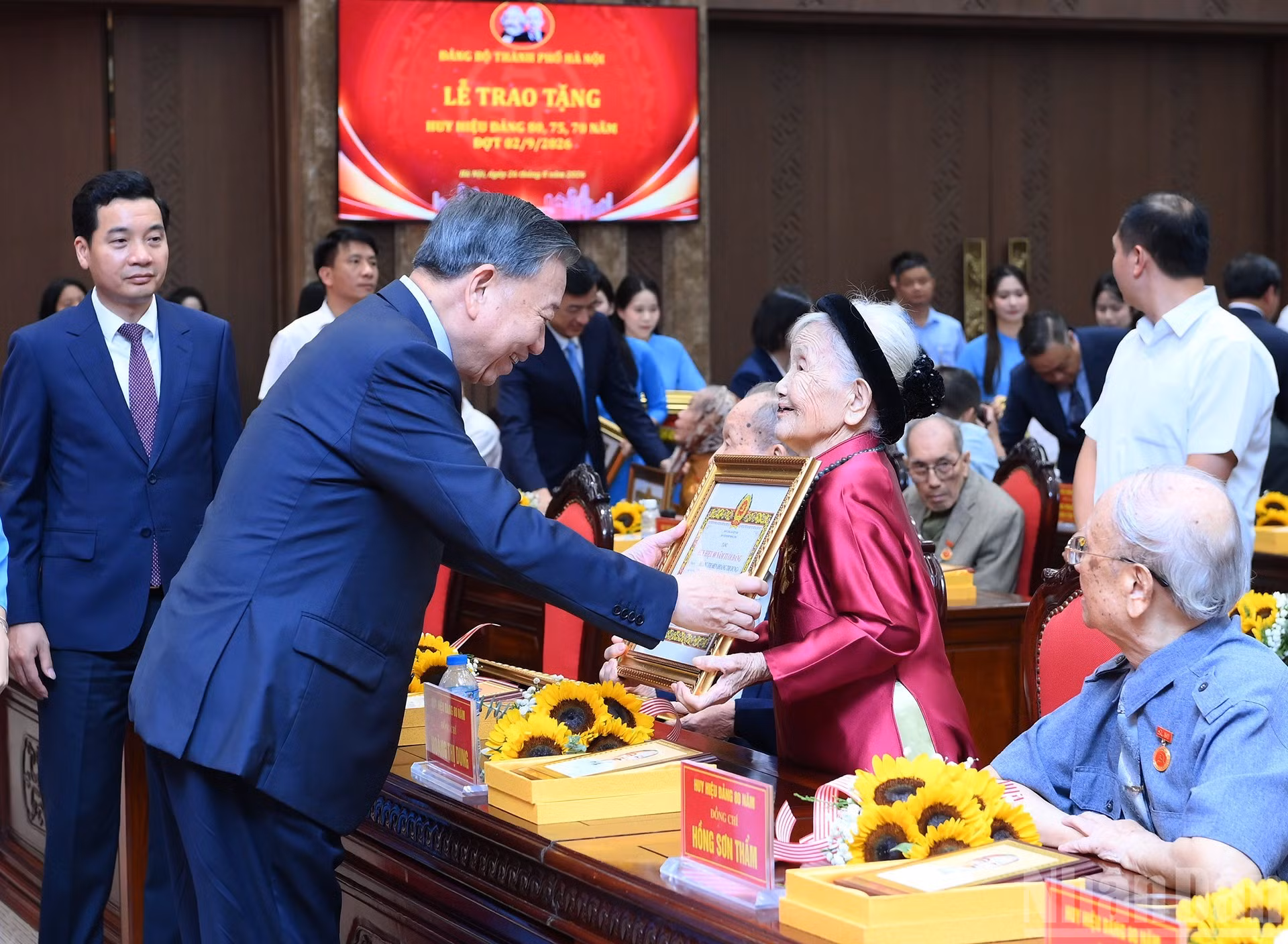 Le secrétaire général du Parti et président de la République To Lam remet l’insigne récompensant 80 années d’adhésion au Parti à la membre du Parti Hoang Thi Dung, de l’organisation du Parti de Hanoi.