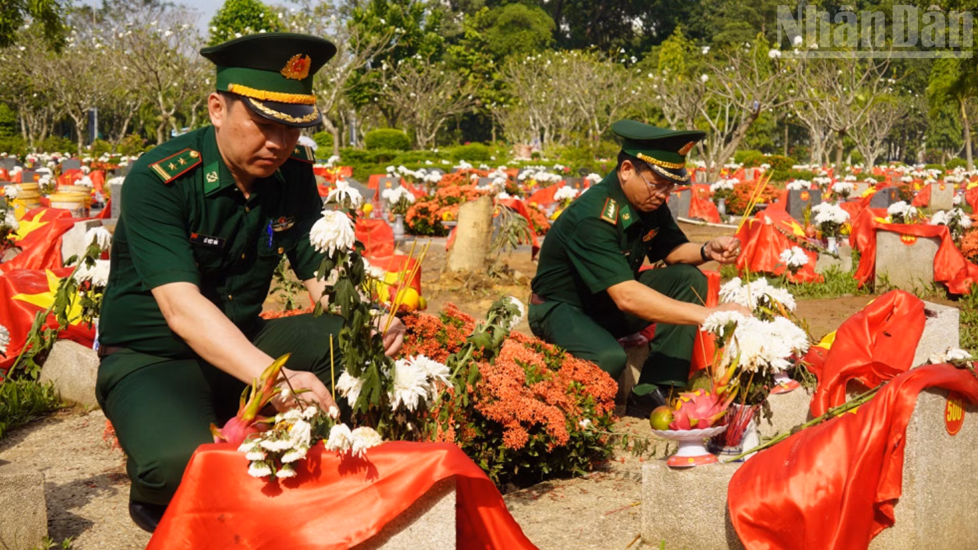 Des membres de la délégation du Commandement des gardes-frontières brûlent de l’encens devant les tombes des soldats dont les dépouilles ont été exhumées au parc Le Thi Rieng avant d’y être inhumées.