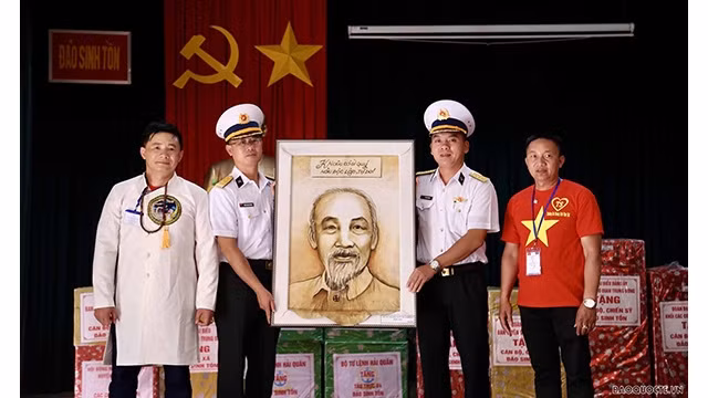 Le président de l'Association vietnamienne en Mongolie, Nguyên Huy Tuân (à gauche), offre la photo du Président Hô Chi Minh aux soldats et aux habitants de Truong Sa. Photo : baoquocte.vn