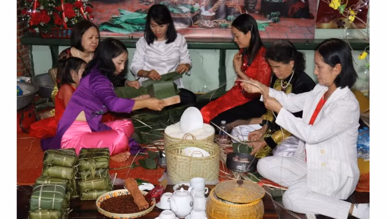 Des Vietnamiens de Vientiane participent à la confection des banh chung. Photo : NDEL.