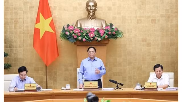 Le Premier ministre Pham Minh Chinh (debout) à la réunion périodique du gouvernement d’août portant sur l'édification de la loi. Photo : VNA.