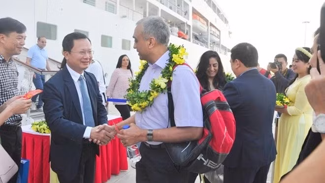 Le vice-président du Comité populaire provincial de Quang Ninh, Cao Tuong Huy (aux lunettes), offre des fleurs aux visiteurs. Photo: VNA.