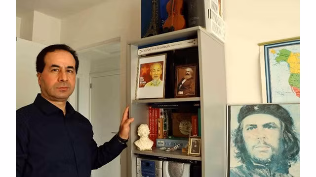 Ahmet Yasar et les photos de l'Oncle Hô dans le bureau de sa maison. Photo : VNA.