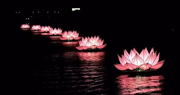 7 fleurs de lotus illuminées sur la rivière Huong dans la soirée du 8 mai. Photo : tuoitre.vn.