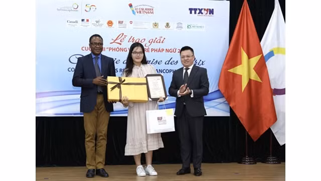 Le vice-directeur général de la VNA, Lê Quôc Minh (droite), et le représentant du BRAP-OIF, Chékou Oussouman, remettent des prix à Man Khanh Ly, lauréate du premier prix. Photo : Hoàng Hiêu/VNA.
