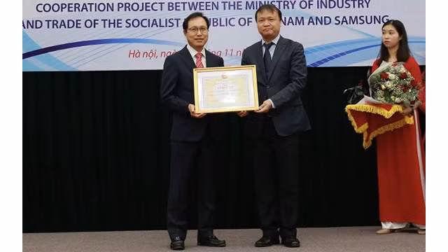 Le vice-ministre de l’Industrie et du Commerce Dô thang Hai remet le satisfecit décerné à la Sarl Sam Sung Electronics Vietnam au directeur général de Samsung Vietnam Choi Joo Ho. Photo: NDEL