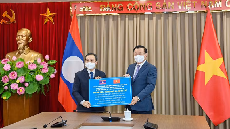 Le secrétaire du Comité du Parti de Hanoï, Dinh Tiên Dung (à droite), remet symboliquement des cadeaux de soutien à Vientiane et aux huit provinces du Nord du Laos. Photo : HNM.