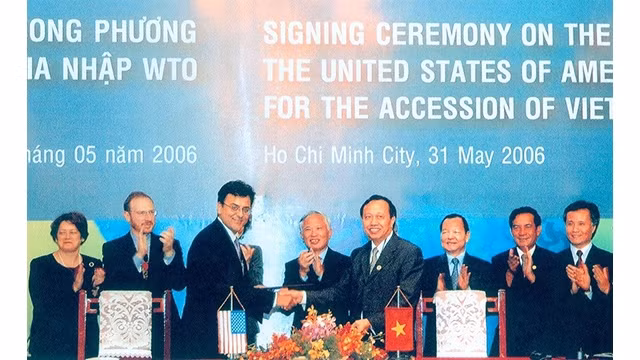 La cérémonie de signature de l'accord d'adhésion à l'OMC avec les États-Unis entre Bhata Karan, représentant adjoint de l'USTR et Luong Van Tu, vice-ministre de l'industrie et du commerce, chef de l'équipe de négociation pour adhérer à l'OMC, en présence du vice-Premier ministre Vu Khoan. Photo: baoquocte.vn