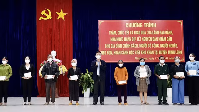 Vo Van Thuong, membre du Bureau politique et Permanent du Secrétariat du Comité central du PCV (5e à partir de la gauche) offre des cadeaux aux pauvres du district de Minh Long, province de Quang Ngai (au Centre). Photo : VGP.