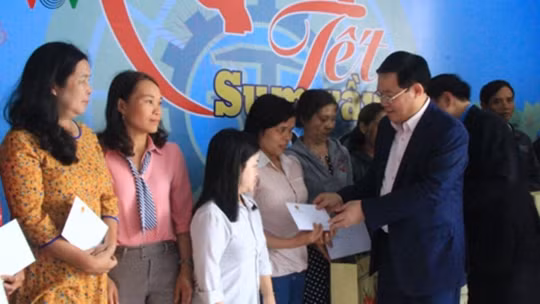 Le vice-Premier ministre Vuong Dinh Huê remet des cadeaux aux travailleurs en difficulté. Photo: VOV