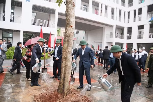 Le président du comité populaire municipal, Nguyên Duc Chung et les dirigeants de l’arrondissement de Hà Dông, plantent un arbre au collège Lê Loi. Photo : VPG