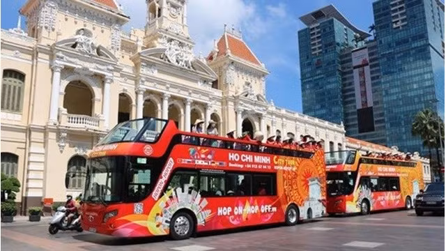 Des touristes visitent Hô Chi Minh-Ville en bus. Photo : VNA.