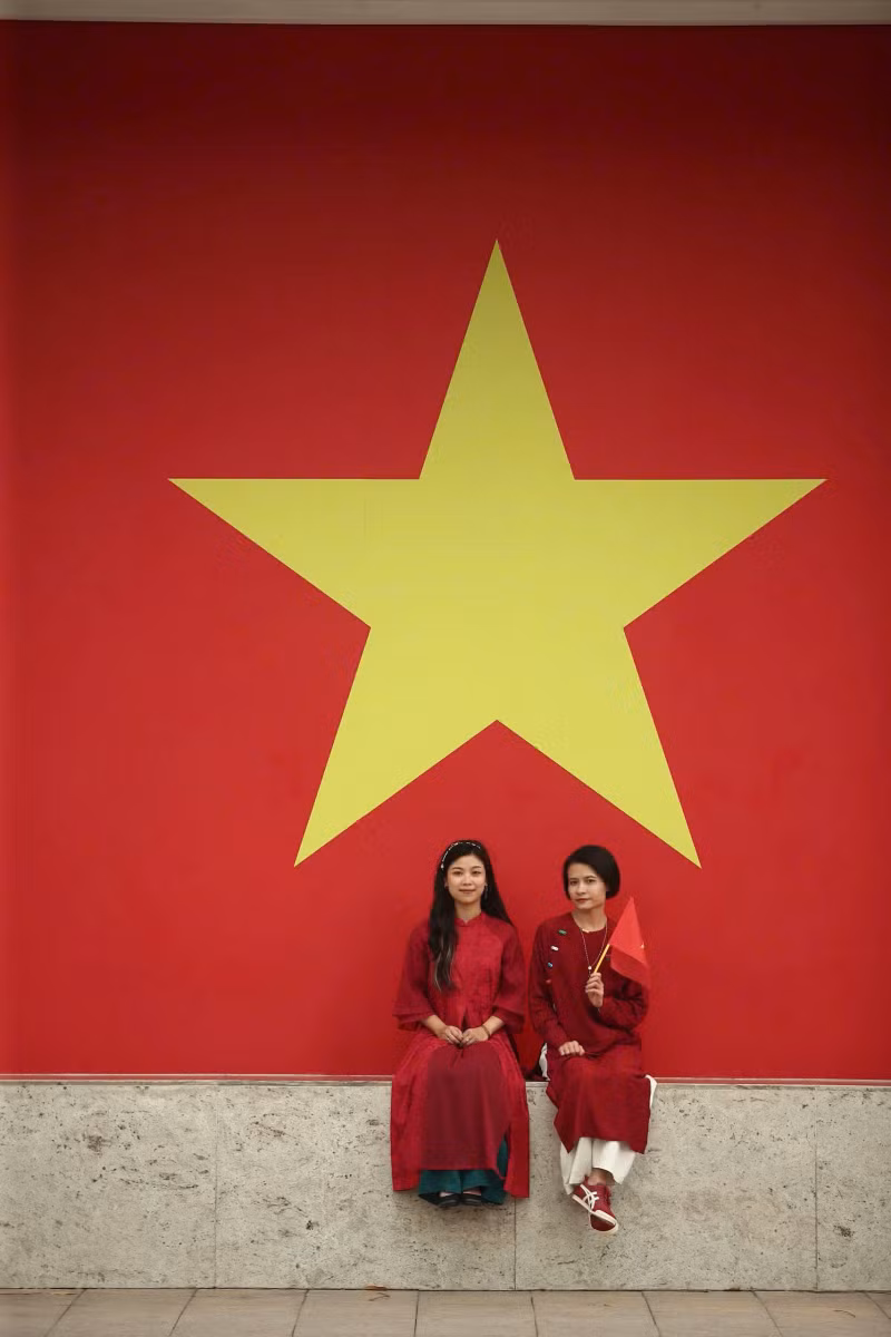 Deux touristes prennent une photo avec le drapeau national. Photo : VGP. Deux touristes prennent une photo avec le drapeau national. Photo : VGP.