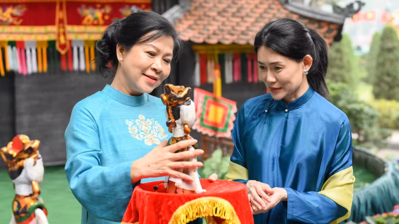 Mme Ngô Phuong Ly (à gauche), épouse du secrétaire général To Lam, a offert une marionnette sur l'eau à Mme Loo Tze Lui, épouse du Premier ministre singapourien Lawrence Wong. Photo : NDEL.